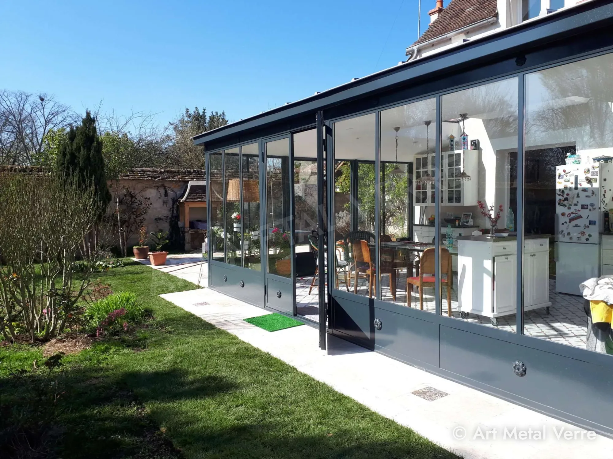 Véranda acier et verre ouverte sur le jardin – Art Metal Verre